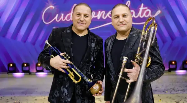 Dwóch muzyków z orkiestry Golec trzyma instrumenty: jeden trąbkę, drugi puzon.