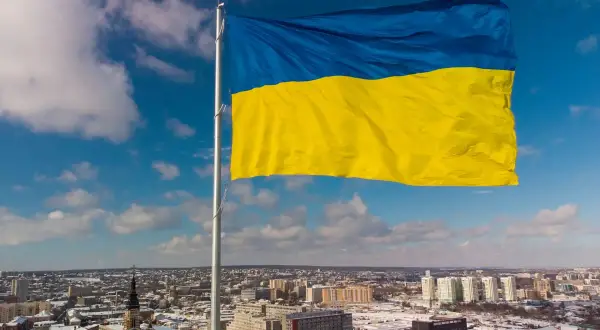 Ukraińska flaga powiewa nad miastem. Chcesz wiedzieć, jak wysłać paczkę na Ukrainę?