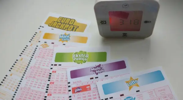 Losy na gry liczbowe Eurojackpot, Mini Lotto, Ekstra Pensja, Multi Multi i Lotto obok budzika.