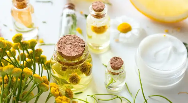Zutaten für anti-falten augencreme selber machen: Öle, Kräuter, Zitrone und eine Creme.