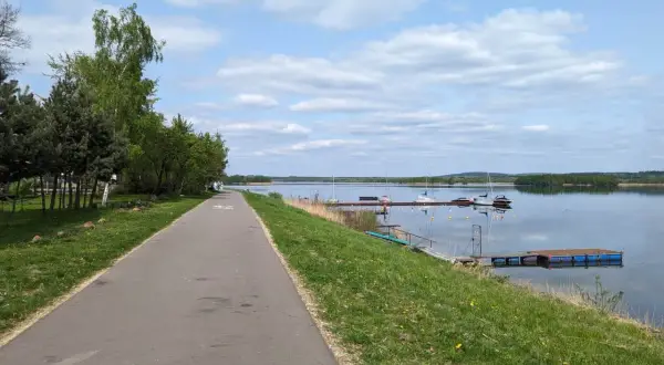 Ścieżka rowerowa wzdłuż jeziora, gdzie cumują żaglówki. Pogoria 4 zaprasza do aktywnego wypoczynku.