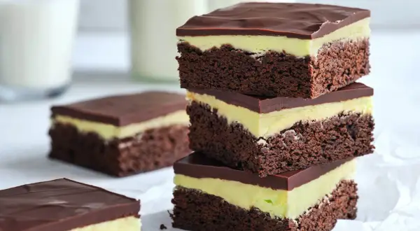 En stapel chokladiga brownies i långpanna med mintgrön fyllning och chokladglasyr. Perfekt för fikat!
