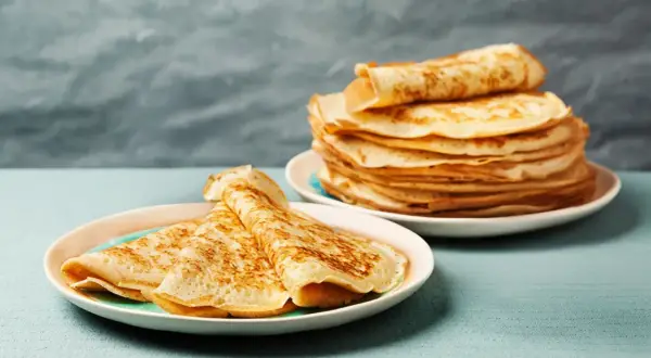 Gestapelte Pfannkuchen auf Tellern, bereit für ein köstliches Pfannkuchen Rezept.