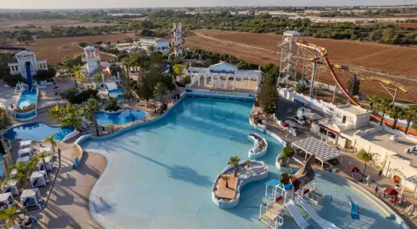 Aerial view of a water park with slides, pools, and a wave pool.