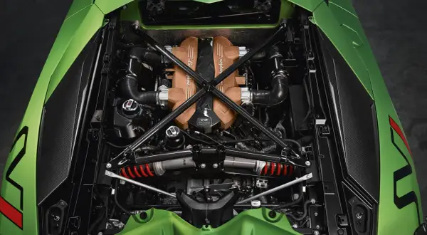 Silnik V12 Lamborghini Aventador SVJ w całej okazałości, z elementami z włókna węglowego i miedzianymi pokrywami.