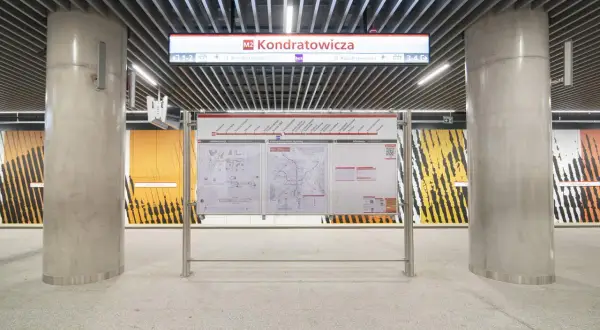 Stacja metra M2 Kondratowicza w Warszawie. Na peronie znajduje się tablica informacyjna z mapą linii i schematem stacji.