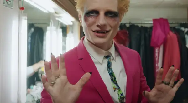 Ed Sheeran w różowej marynarce i makijażu wampira, gotowy do wykonania swoich największych przebojów.