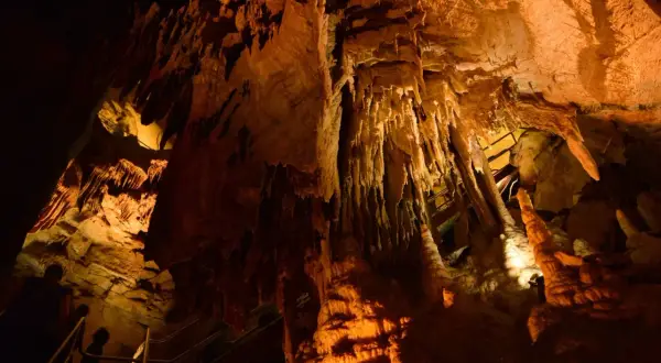 Wnętrze jaskini z naciekami, stalaktytami i stalagmitami, oświetlone ciepłym światłem. Możliwe, że to najdłuższa jaskinia na świecie.