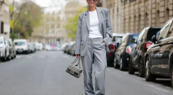 Elegancka stylizacja smart casual damski lato: szary garnitur, biały top, sneakersy i torebka Fendi.