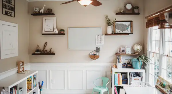 Inspiring modern homeschool room ideas: shelves with decor, a whiteboard, and organized storage create a functional and beautiful learning space.