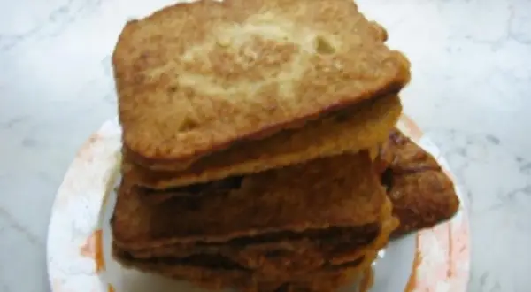 Ein Stapel goldbraunes Brot mit Ei, auf einem Teller angerichtet. Perfekt für ein herzhaftes Frühstück.