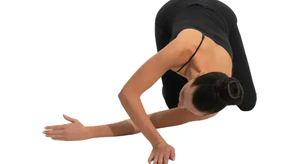 Donna in posa yoga, con le scapole alate che si aprono in un movimento fluido.
