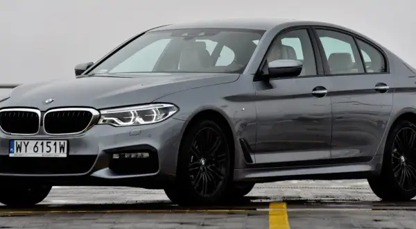 Szary sedan BMW Serii 5, z czarnymi felgami i tablicą rejestracyjną WY 6151W. Poznaj jego bmw 5 dane techniczne.
