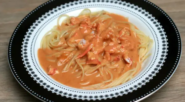Pâtes au homard crémeuses, un délice servi dans une assiette décorée.