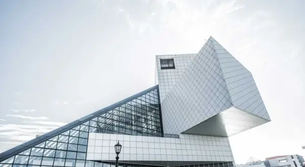 Un bâtiment aux formes géométriques audacieuses, capturé par un photographe architecture. La structure blanche et vitrée se détache sur un ciel clair.