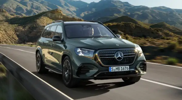 Zielony Mercedes-Benz GLS przemierza malowniczą, górską drogę.