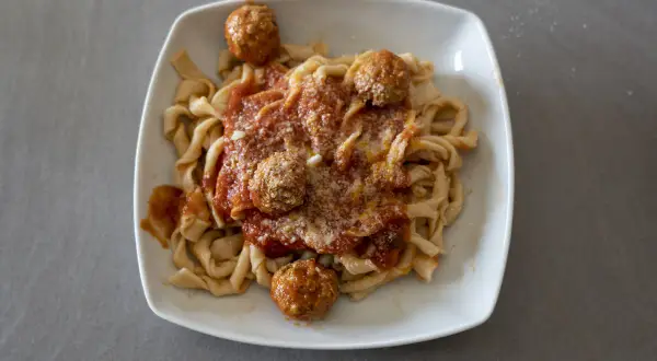 Sagne ncannulate con polpette al sugo, un piatto ricco e saporito, pronto per essere gustato.