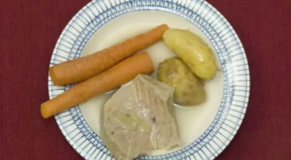Ein deftiges Gericht: zarte Karotten, Kartoffeln und ein Stück Fleisch, das an Kuheuter erinnert, schwimmen in einer Brühe.