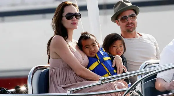 Angelina Jolie med sina barn på en båt. En av barnen bär en blå flytväst.