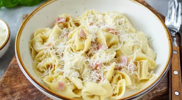 Schon gewusst? Tortellini einfrieren ist eine tolle Idee, um sie später zu genießen. Hier sind sie mit Schinken und Parmesan serviert.