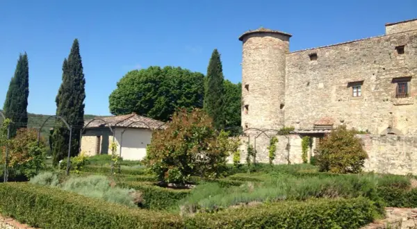 Giardino all'italiana con torre medievale, un luogo dove i sogni del Chianti prendono vita tra siepi curate e profumi di lavanda.