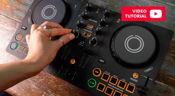 Dłoń DJ-a manipuluje pokrętłami na czarnym kontrolerze DJ-skim DDJ-FLX2.