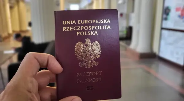 Dłoń trzyma polski paszport. Ważność paszportu jest kluczowa do podróży.