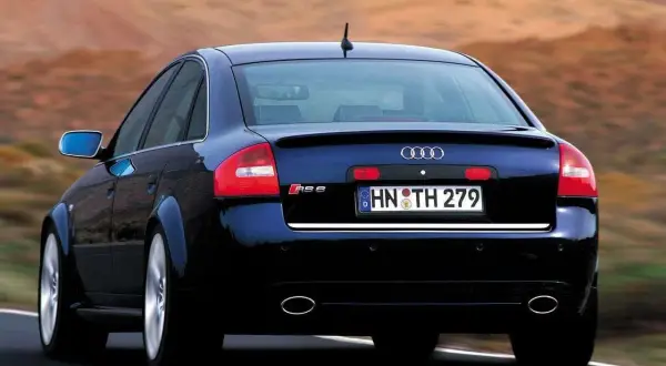 Ciemnoniebieskie Audi RS6 C5 z tablicą rejestracyjną HN TH 279 jedzie po drodze.