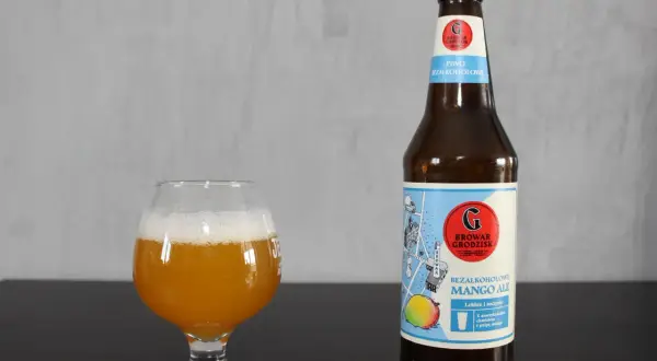 Szklanka z bursztynowym piwem i butelka bezalkoholowego mango ale Browaru Grodzisk.
