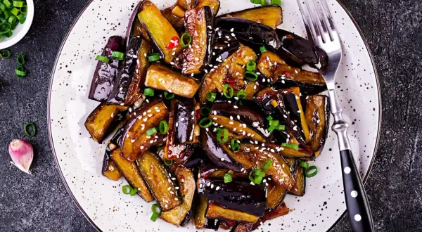 Aubergines laquées, parsemées de sésame et d'oignons verts. Une recette savoureuse pour sublimer ce légume.