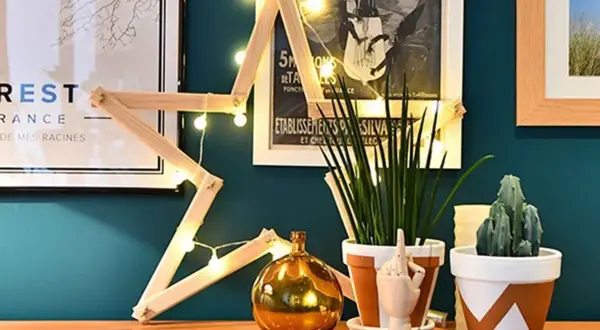 Étoile en bois faite maison, décorée de guirlandes lumineuses. Une décoration simple pour fabriquer une étoile en bois.