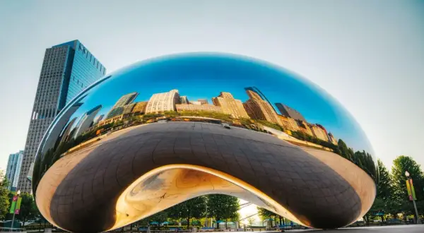 Lśniące dzieła Anish Kapoor odbijają panoramę miasta.