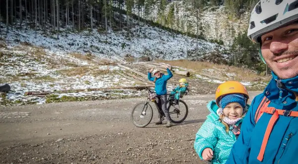 Rodzina na rowerach odkrywa tatrzańskie trasy rowerowe. Radosne dzieci i rodzice cieszą się zimowym krajobrazem.
