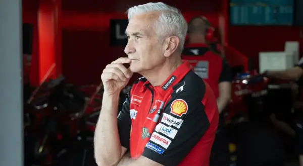 Davide Tardozzi, con su mano en la barbilla, reflexiona en el box de Ducati.