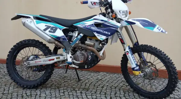 Husqvarna 250 FE z numerem 79, gotowy do akcji na wyboistym terenie.