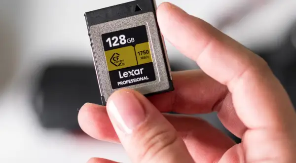 Dłoń trzyma kartę pamięci Lexar 128GB CFexpress B, gotową do włożenia do telefonu lub aparatu.
