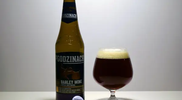 Butelka i kielich z ciemnym piwem barley wine "Po Godzinach". Etykieta informuje o edycji limitowanej.