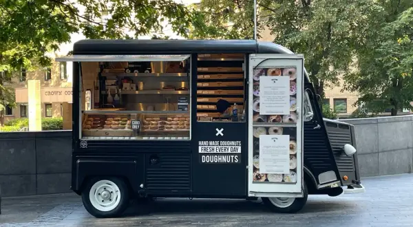 Food truck nero con ciambelle fatte a mano, fresche ogni giorno.