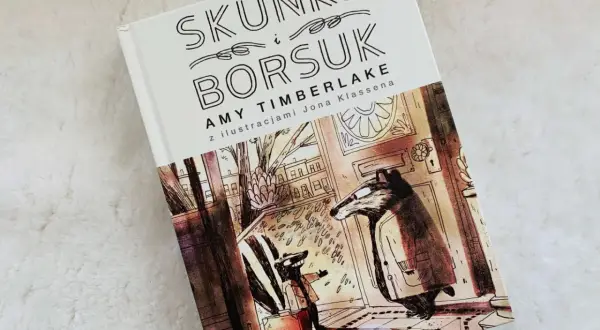 Skunks i Borsuk – idealne książki na dobranoc. Ilustracja przedstawia dwóch borsuków w płaszczach, jeden z walizką, gotowych na przygodę.