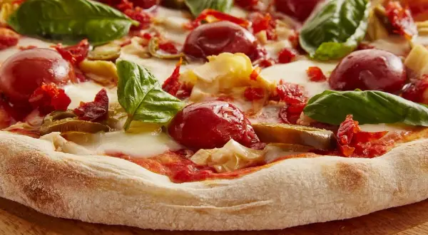 Gotowe ciasto na pizzę z pomidorkami, mozzarellą i bazylią. Idealne na szybki obiad.