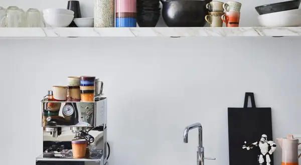 Stilvolle Kaffeebar Ideen: Chrom-Espressomaschine mit bunten Tassen, Marmorregal mit Geschirr und ein Stormtrooper-Dekor.