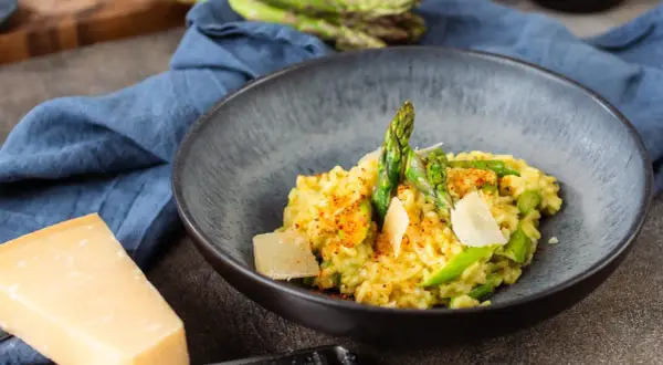 Cremiges Risotto mit frischem Spargel und Parmesan, garniert mit Paprikapulver. Ein Genuss für alle Sinne!