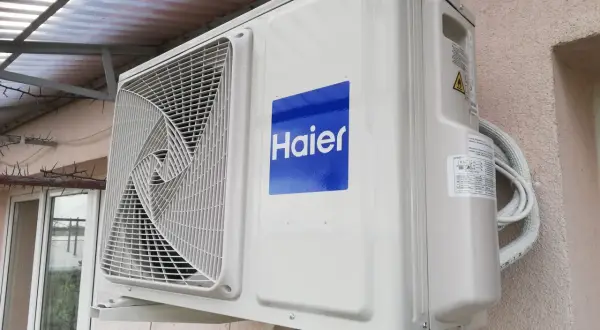 Jednostka zewnętrzna klimatyzatora Haier zamontowana na ścianie budynku.