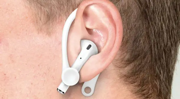 Ucho z białą słuchawką AirPods i zaczepem, pokazujące, jak poprawnie nosić Airpods dla lepszego dopasowania.
