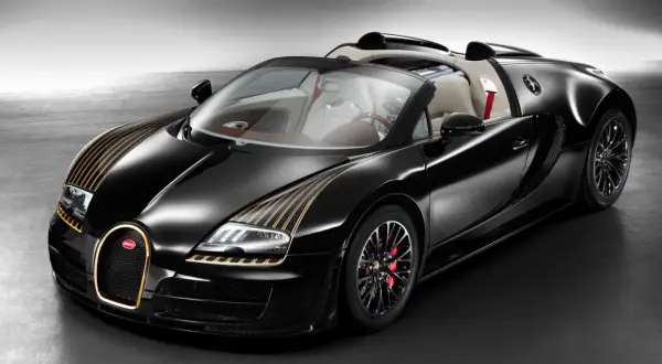 Czarny Bugatti Veyron z złotymi pasami na masce i złotą obwódką grilla. Kabriolet z jasnym wnętrzem.