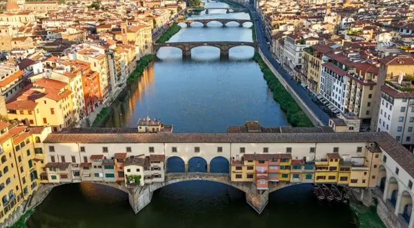 Mostra Ponte Vecchio, jeden z głównych punktów, które warto zobaczyć we Florencji, z kolorowymi budynkami i rzeką Arno.