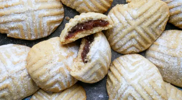 Maamoul Kekse, mit Puderzucker bestäubt, zeigen ihr köstliches Dattelfüllungs-Maamoul-Rezept.