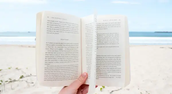 Otwarta książka na plaży, idealna lekka książka na wakacje.