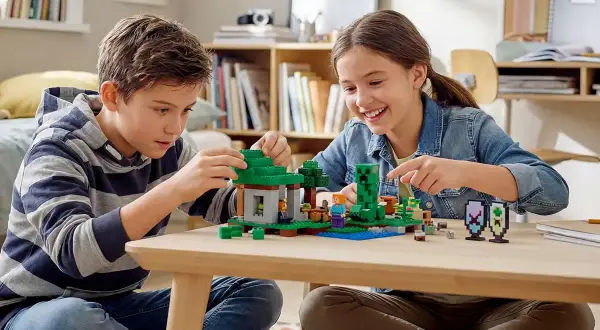 Dzieci budują z klocków Minecraft, tworząc jedną z najlepszych gier LEGO. Radość i kreatywność na twarzach maluchów.