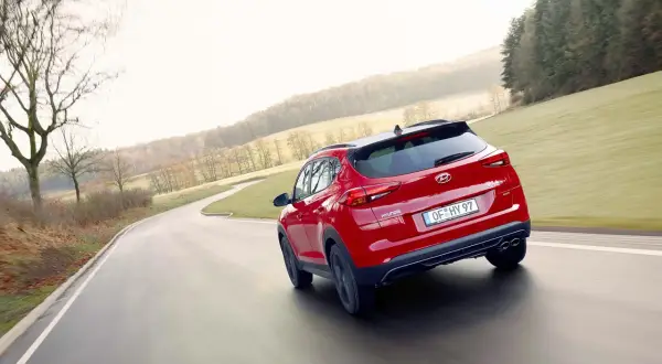 Czerwony Hyundai Tucson na zakręcie drogi. Zastanawiasz się, jaki silnik wybrać do swojego Tucsona?